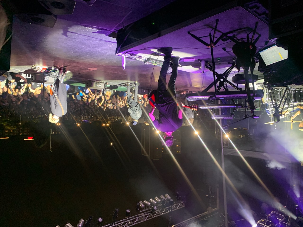 Concert crowd and stage lit by beam lights